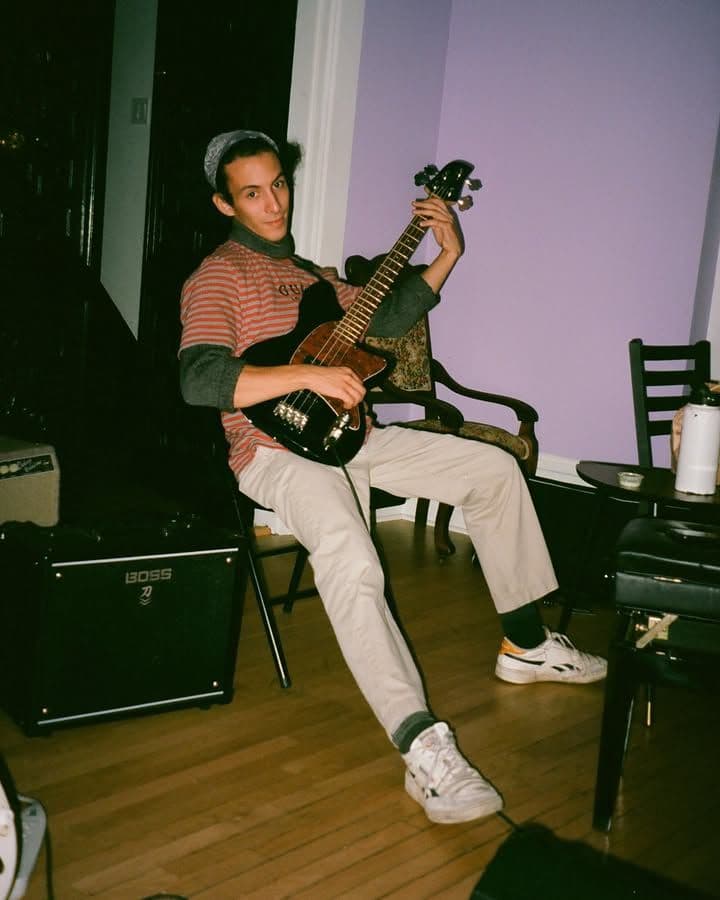 bassist laying back in a chair smiling